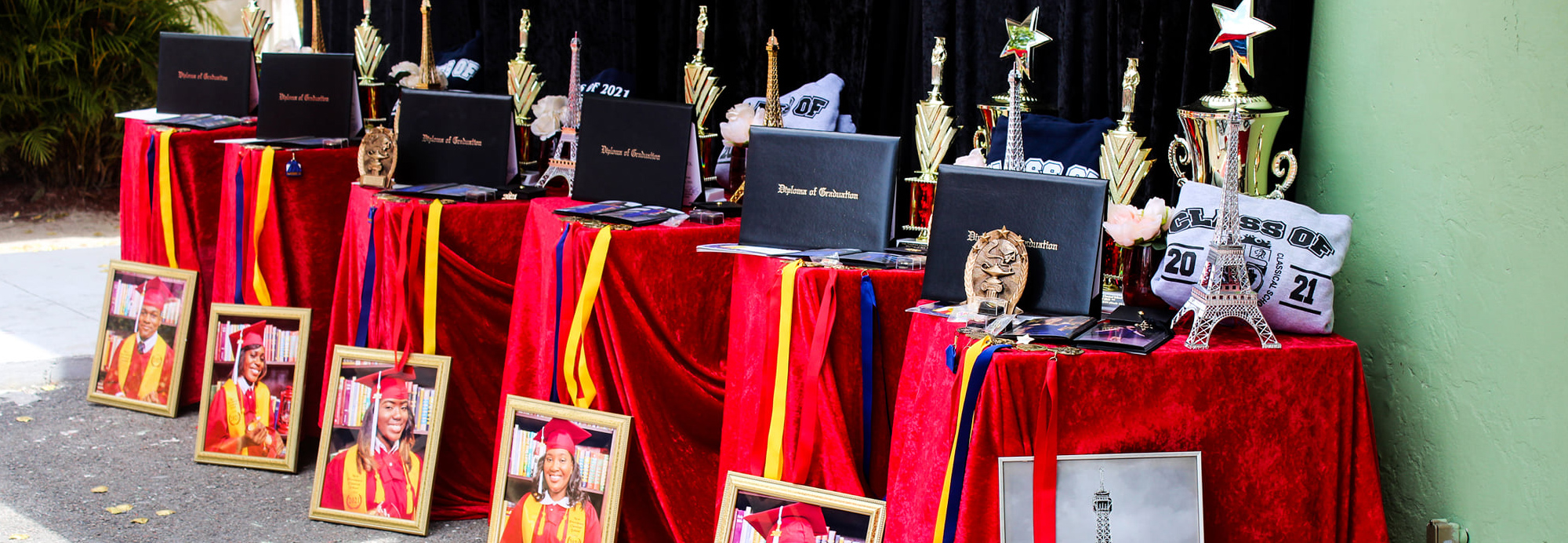 Graduation diplomas and awards displayed on red tables